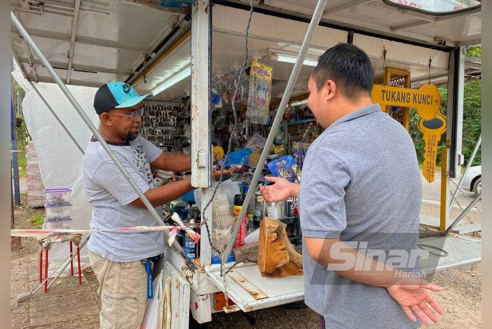Mohd Azlan melayan pelanggan yang membuat kunci motosikal di kedainya.