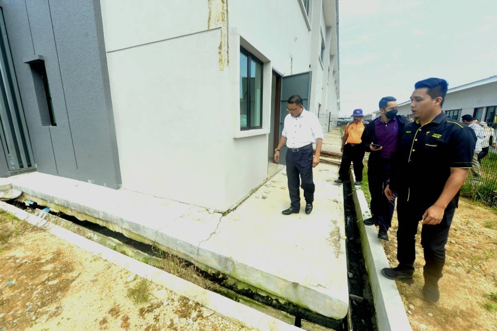 Johari inspecte mardi des fissures dans la structure d'une maison dans un lotissement à Tanjung Lumpur.