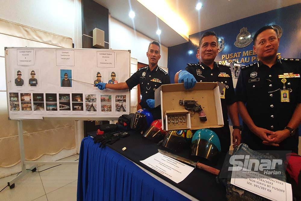 Mohd Suhaily (kiri) menunjukkan foto suspek yang terlibat dalam kes samun bersenjata manakala Rahimi (dua dari kanan) menunjukkan pistol yang dirampas.