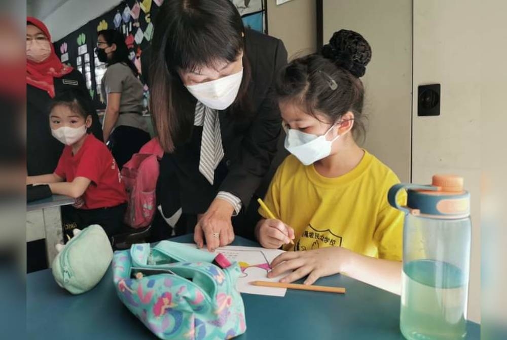 Hui Ying ketika melawat murid yang mengikuti kelas pembelajaran mereka pada hari pertama persekolahan.