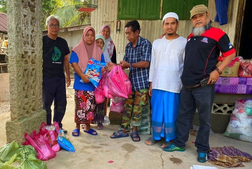 (Dari kiri) Razak, Nur Bahagia, Farid dan Abdul Halim berbekalkan wang berjumlah RM30,000 dan dua buah pacuan empat roda sanggup mengerah keringat menyantuni mangsa banjir di Kelantan dan Terengganu.
