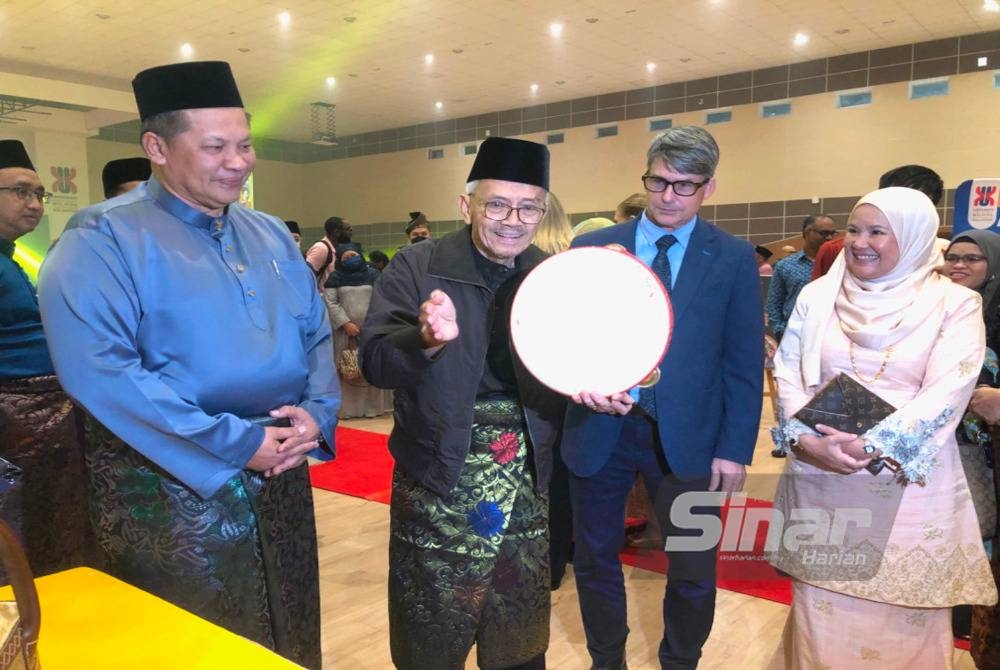 MCFreeters (dua dari kanan) dan Razli (kiri) melihat Harun Hasan (dua dari kiri) memainkan alat muzik, rebana kercing.