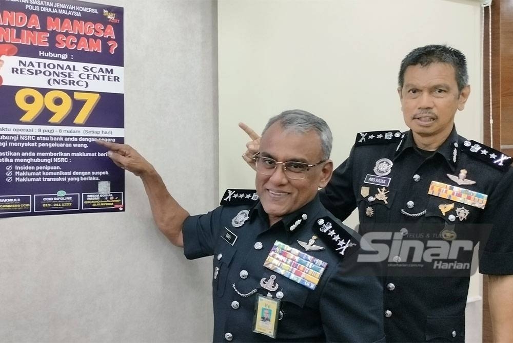 Ramli menunjukkan poster kempen kesedaran kes penipuan dalam talian untuk maklumat orang ramai bagi mengelak menjadi mangsa.