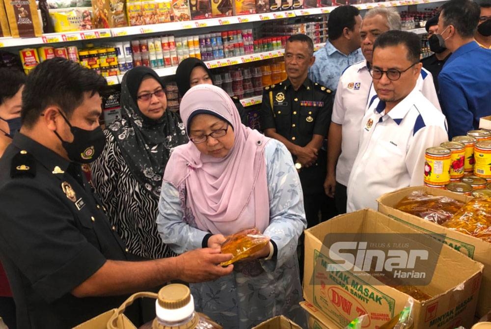 Fuziah (tengah) melihat minyak masak peket yang dijual di sebuah pasar raya di Bachok.