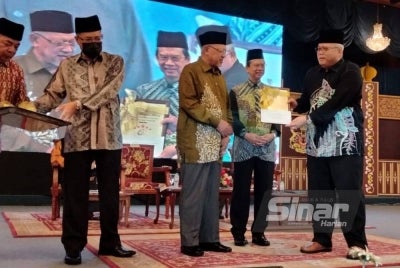 Nazran (dua dari kanan) mengiringi Ahmad menyampaikan Anugerah Pihak Berkuasa Tempatan Cemerlang kepada Yang Dipertua Majlis Perbandaran Kota Bharu, Rosnazli Amin (kanan).