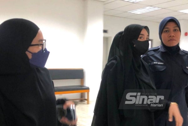 Nur Farhana (kiri) dan Anes Ayunie (tengah) ketika hadir di Mahkamah Majistret pada Khamis.