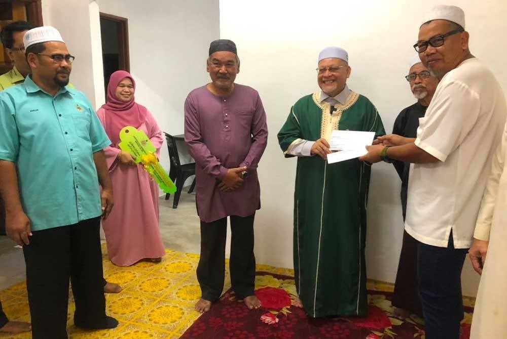 Mohd Amar (tiga dari kanan) menyampaikan cek bernilai RM60,000 kepada Setiausaha Masjid Al-Alaq, Rawi Hamid (kanan).