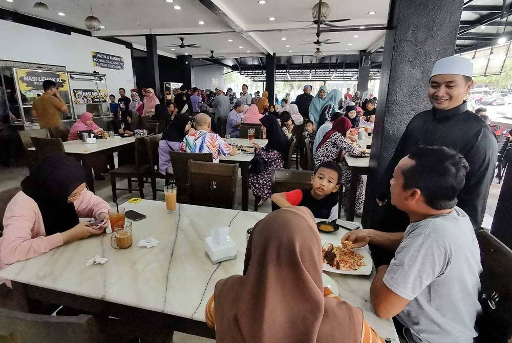 Raja Abdul Salam (kanan) menyapa pelanggan yang berkunjung ke Restoran DSH di Batu Buruk, Kuala Terengganu.
