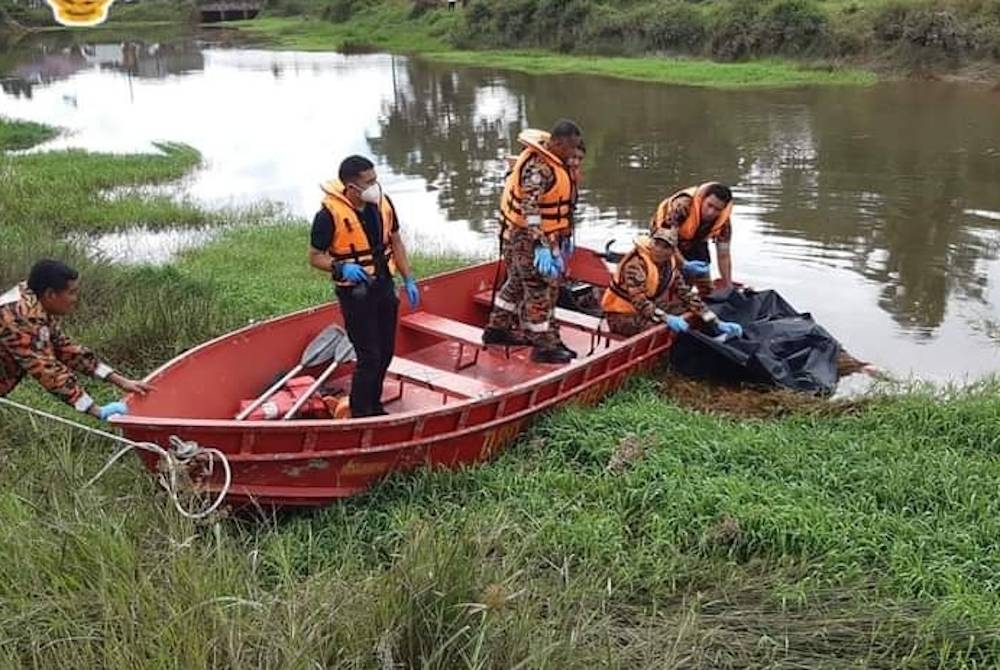 Anggota bomba menaikkan mangsa yang ditemukan lemas di Sungai Seneng, Jelawat Bachok pada Khamis. - Foto ihsan JBPM
