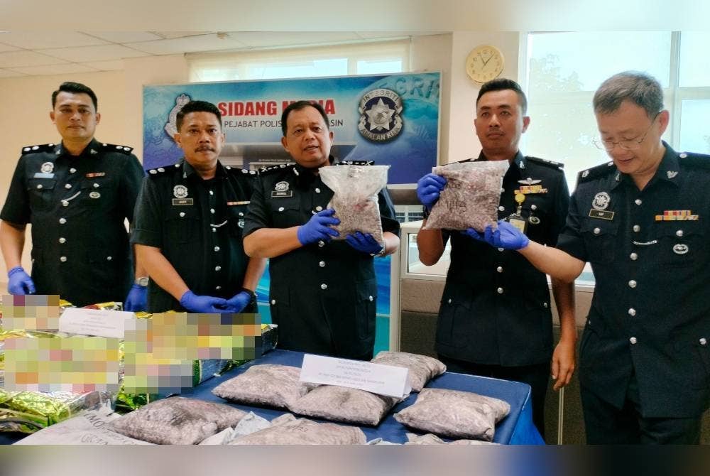 Zainol (tengah) menunjukkan sebahagian pil ekstasi yang dirampas dalam serbuan di sebuah rumah di Serkam pada Rabu lalu.