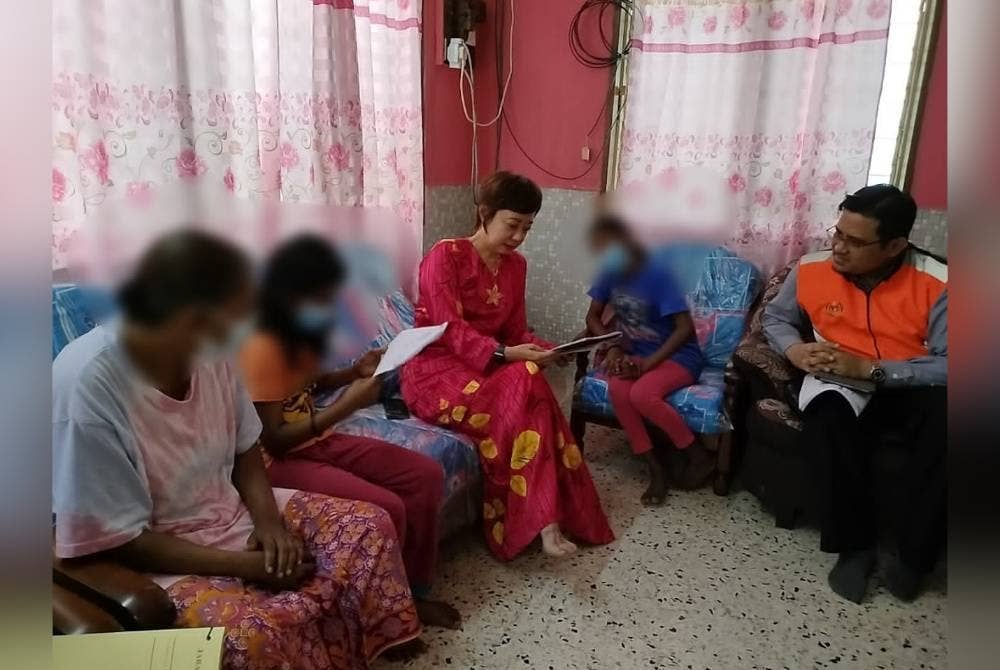 Nicole (tiga dari kiri) ketika menziarahi dua beradik itu di Temiang pada Jumaat.