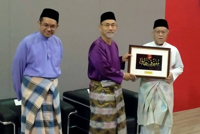 Wan Zahidi (kanan) menyampaikan cenderahati kepada Nooh (tengah) selepas menjadi panel program Liqa' Fikri Bersama Pengerusi Muzakarah MKI dan Mufti Perak di Auditorium Universiti Sultan Azlan Shah di sini pada Jumaat.