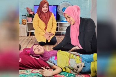 Nur Zulaikha (kanan) ketika menerima kunjungan Che Norhayati di rumahnya di Kampung Gatal, Kuala Krai.