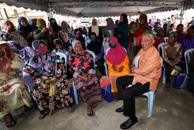 Al-Sultan Abdullah berkenan beramah mesra bersama warga Orang Asli ketika melawat ke Kampung Orang Asli Kuala Boh pada Sabtu. - Foto Bernama