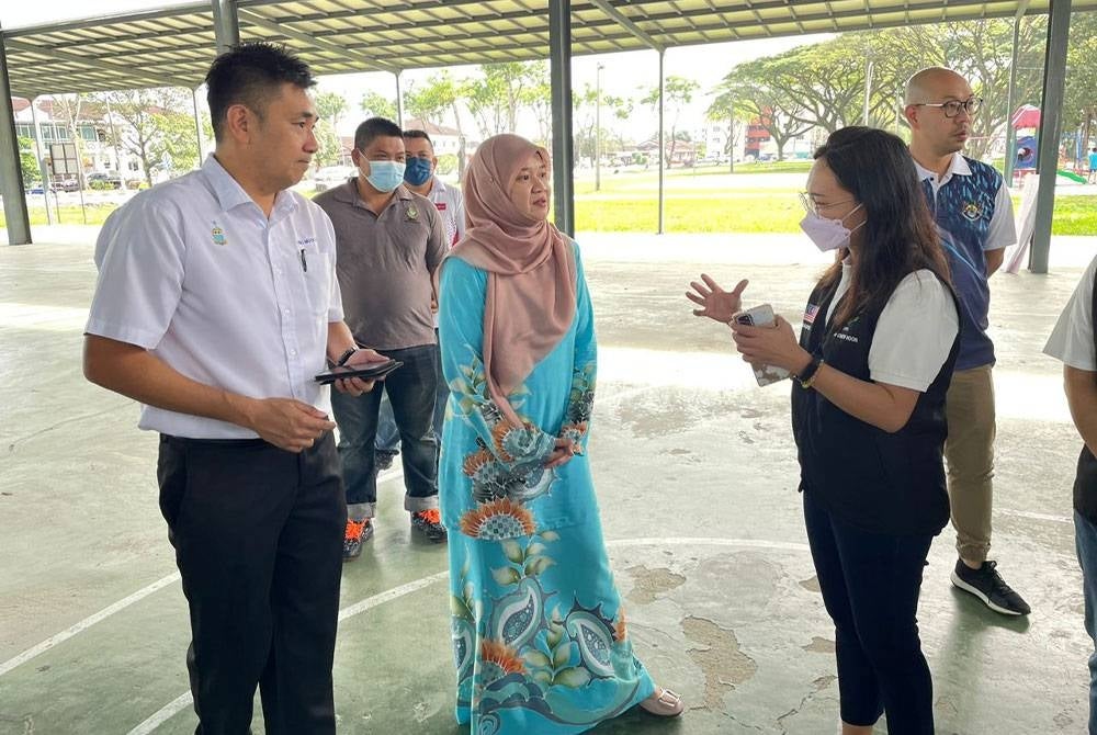 Fadhlina (dua dari kiri) ditemani Ahli Dewan Undangan Negeri (ADUN) Jawi, H'ng Mooi Lye (kiri) berbual dengan wakil badan bukan kerajaan (NGO) mengenai Pasar Percuma 2023 Parlimen Nibong Tebal pada Ahad.