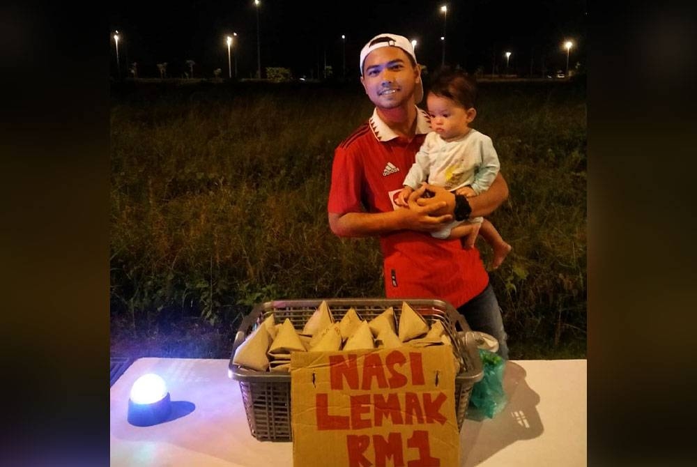 Muhammad Izzat Haikal bersama anaknya, Hanis Dahlia, 8 bulan di lokasi jualan nasi lemak dekat masjid Seberang Takir, di Kuala Nerus.