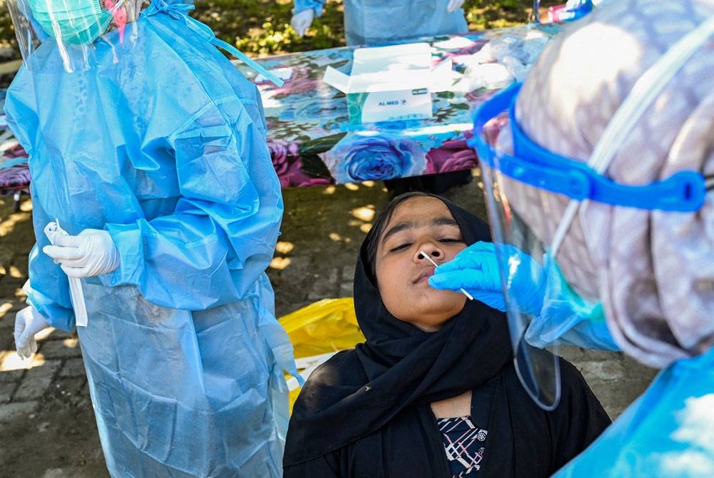 Pelarian Rohingya yang ditempatkan di pusat penempatan sementara di Ladong menjalani ujian saringan Covid-19. - Foto: AFP