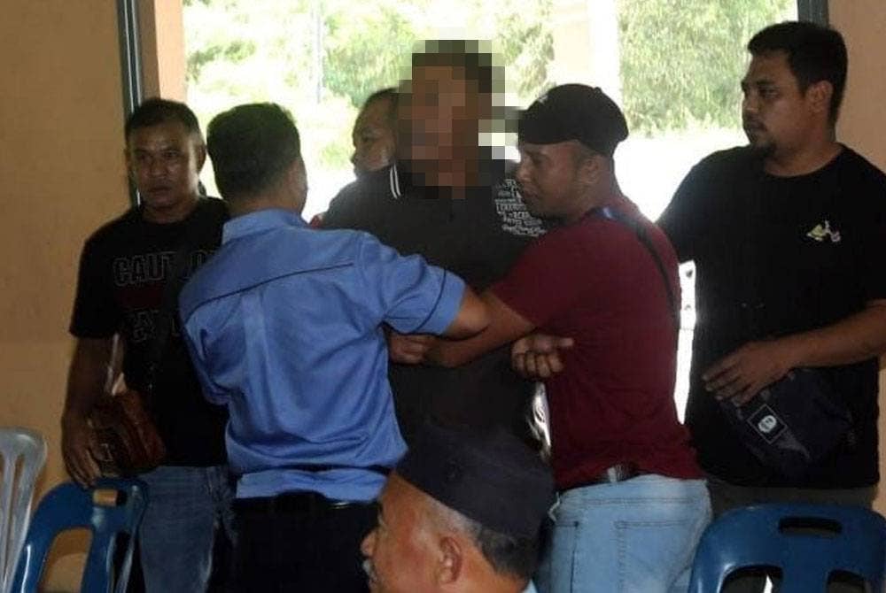 Beberapa penduduk dan anggota polis menenangkan penduduk yang berang berhubung isu pemilikan tanah pertanian di Kampung Kinjang Baru, Chenderiang dalam pertemuan pada Selasa.