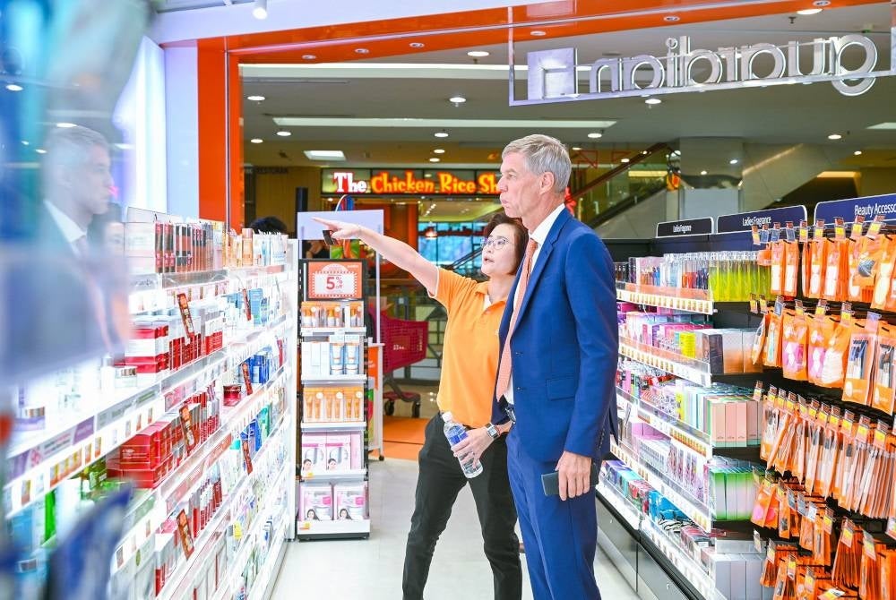 Pengarah Operasi Guardian, Chong Li Ling (kiri) memberikan penerangan kepada Soren Lauridsen (kanan) mengenai stor Guardian yang berwajah baharu.