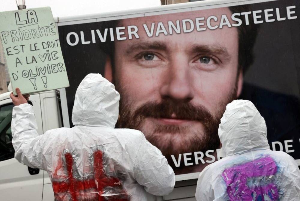 Penunjuk perasaan memegang poster bertulis 'Keutamaan adalah hak hidup untuk Olivier' semasa demonstrasi untuk Olivier Vandecasteele di Brussels, Belgium. - Foto AFP