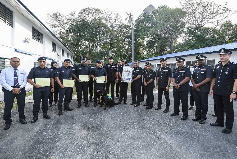 Suresh Kumar bergambar bersama para pegawainya selepas menyampaikan sijil penghargaan dan pingat kepada 'Black' dan pengendalinya, Koperal Johan Anak Jame di Seksyen K9 pada Rabu. - Foto Bernama