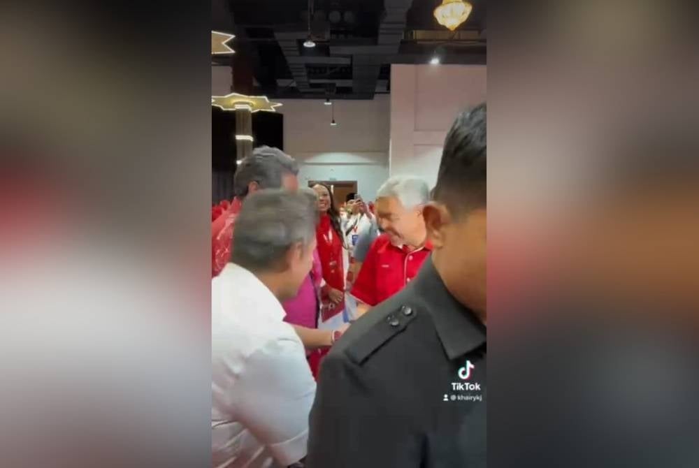 Tangkap layar video yang memaparkan Ahmad Zahid (kanan) bersalaman dengan Khairy.