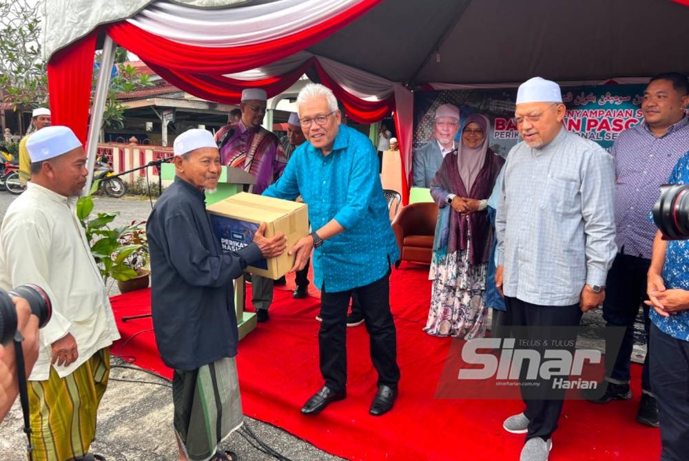 Hamzah (tengah) menyampaikan sumbangan kepada mangsa banjir di Tumpat.