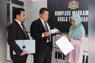 Nor Azlina berbincang dengan peguam Mohd Hazwan (tengah) selepas memfailkan saman di Mahkamah Kuala Terengganu.