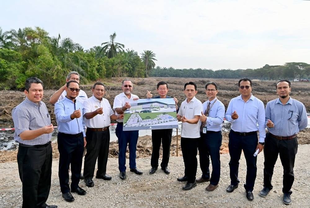 Kon Yeow (enam dari kiri) menunjukkan pelan pembinaan Pasar Awam dan Penjaja Bandar Cassia di tapak pembinaan pada Jumaat.