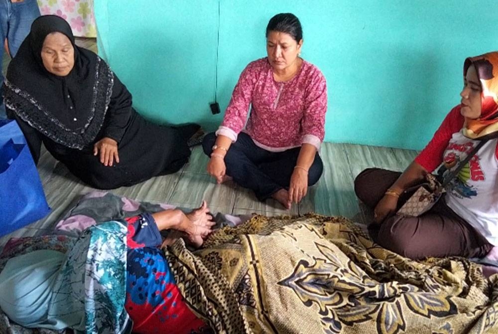 Saraswathy (tengah) bertanya khabar dan menyampaikam sumbangan kepada Aminah di kediamannya di Kampung Dalam Rhu pada Jumaat.