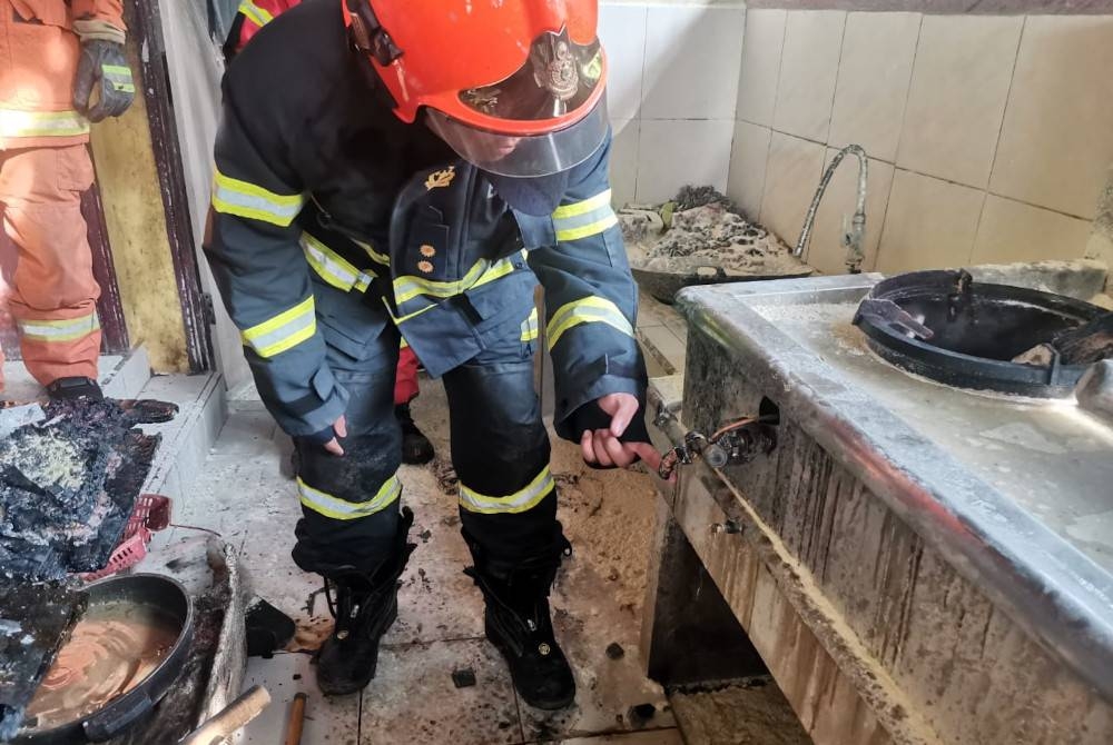 Pasukan bomba membuat pemeriksaan di dapur restoran yang terbakar di Kampung Gumantong Jaya, Kinabatangan pada Jumaat.