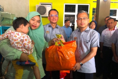 Ahmad Fahmi (kanan) menyampaikan bantuan kepada pembantu operasi Jpen, Siti Aishah Che Amat (kiri) di Tumpat.