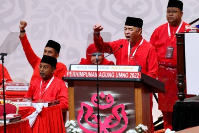 Zambry (duduk, kiri) pada Perhimpunan Agung UMNO 2022 di Pusat Dagangan Dunia (WTC) Kuala Lumpur, pada Jumaat. - Foto Bernama
