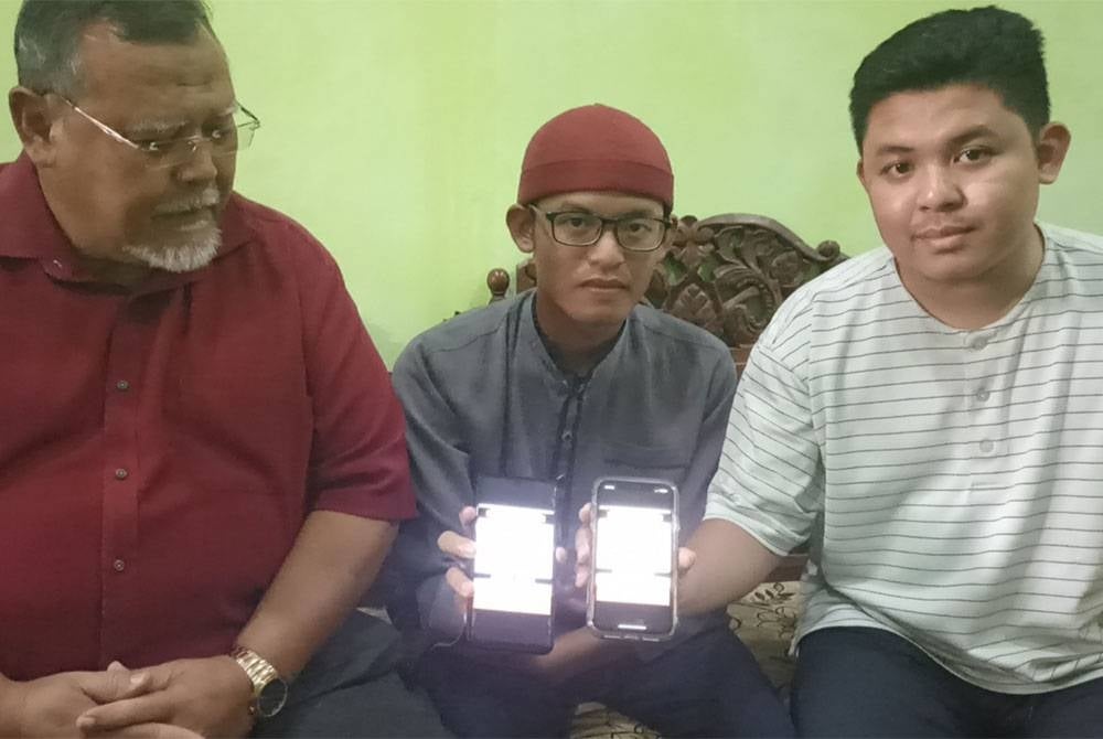 Muhammad Nabil (kanan), Muaz ( tengah) bersama Aminolhuda ( kiri) menunjukkan gambar ayah yang hilang sejak sebulan lalu di Mekah.