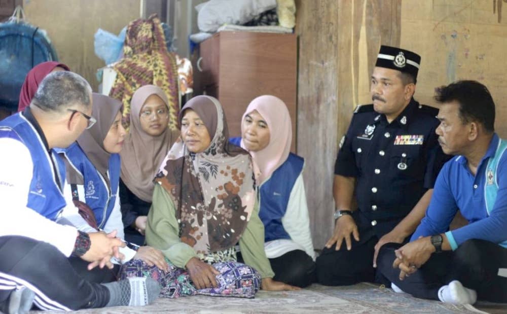 Norizan (tengah) dikunjungi polis dari Ibu Pejabat Polis Daerah Bachok pada Ahad.
