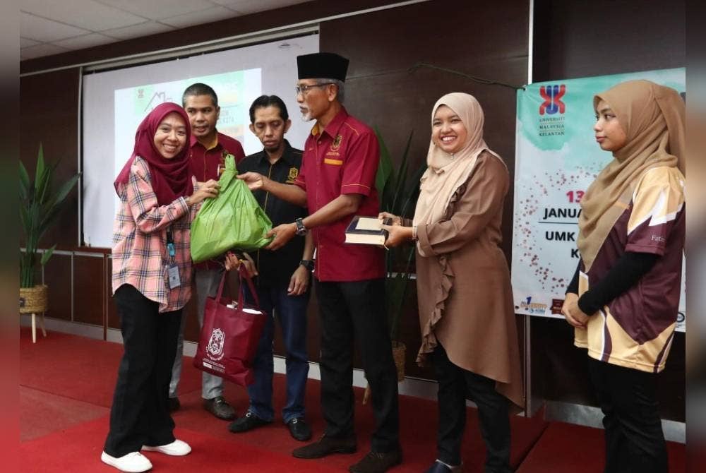 Zakaria (tiga dari kanan) menyampaikan sumbangan kepada penerima pada program We Care We Share. - Foto UMK