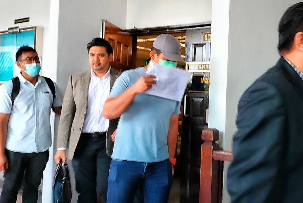 Muhammad Hafizi (tiga dari kiri) ketika keluar dari Mahkamah Seksyen, di sini pada Isnin.