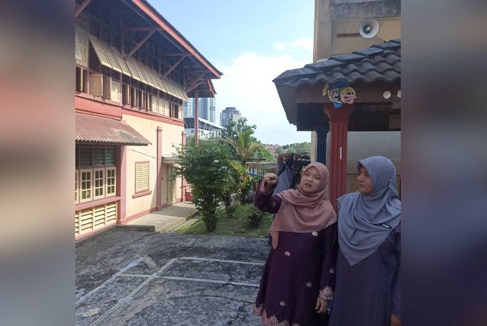 Fadhlina (dua dari kanan) menunjukkan bangunan Sekolah Kebangsaan (Perempuan), Bandar Tinggi Johor Bahru, pada Isnin.