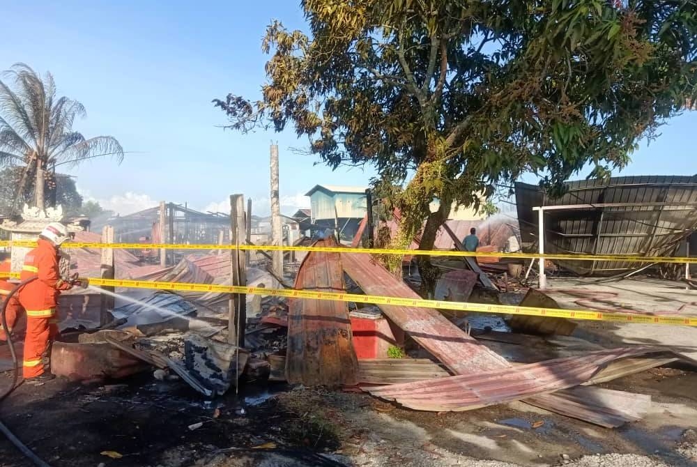 Anggota bomba menjalankan operasi memadam kebakaran enam rumah di Bagan Ikan, Bagan Datuk pada Isnin. - Foto ihsan Bomba Perak