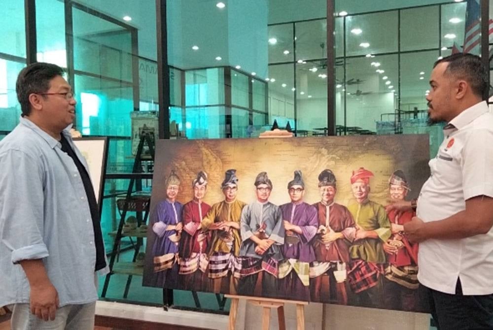Mohd Hasnan (kiri) menunjukkan potret sembilan Perdana Menteri Malaysia kepada Tuan Hissam.