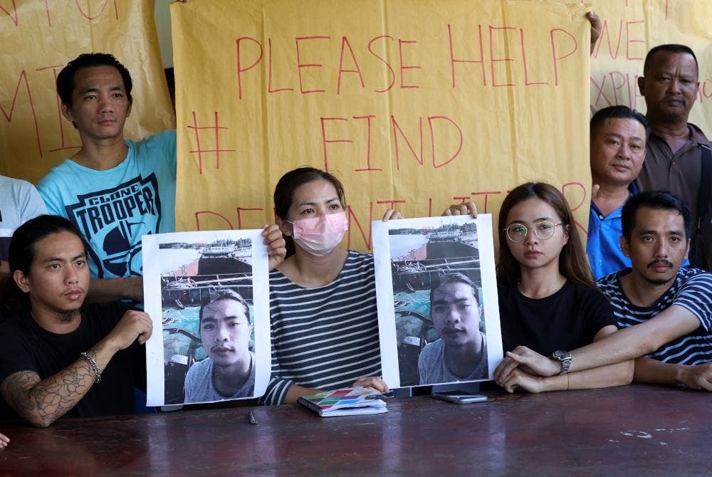Sandra Littor, 32, (depan dua, kiri) bersama adiknya Lyli Littor, 28, (depan dua, kanan) serta saudara terdekat menunjukkan gambar Derrent Littor, 22, anak kapal kargo MV Dai Cat 06 yang dilaporkan hilang di perairan Indonesia sejak 9 Januari lepas. - Foto Bernama.