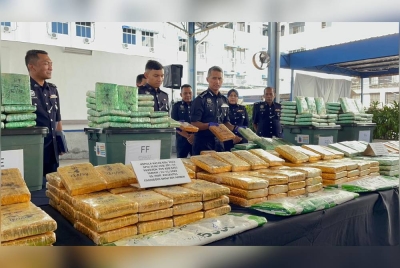 Mohd Shuhaily (tengah) menunjukkan ganja mampat yang dirampas pada sidang media pada Isnin.