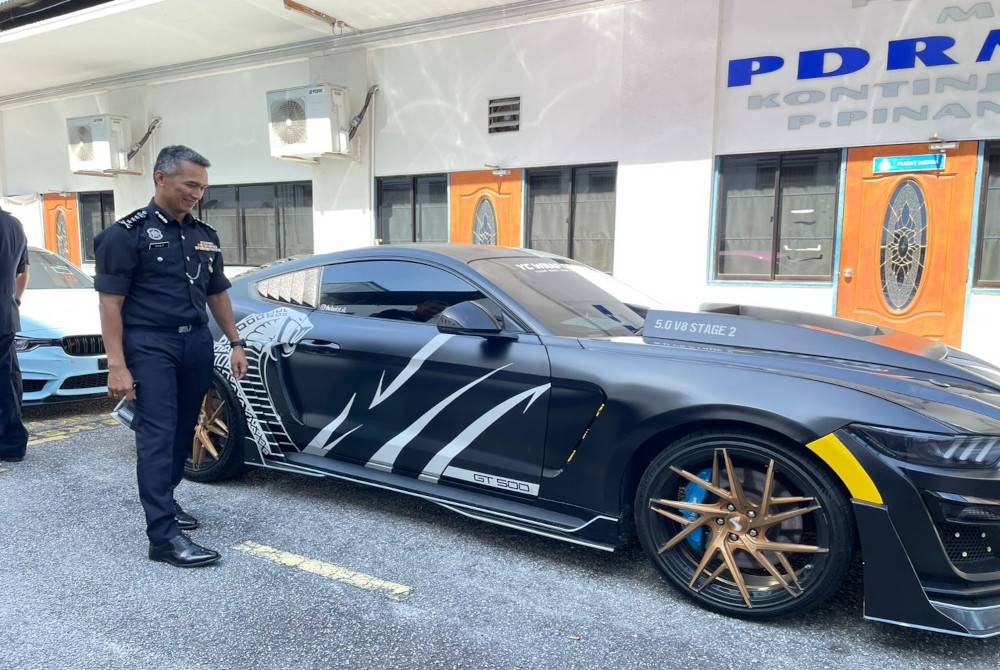 Mohd Shuhaily menunjukkan kereta jenis Ford Mustang yang dirampas daripada salah seorang suspek.