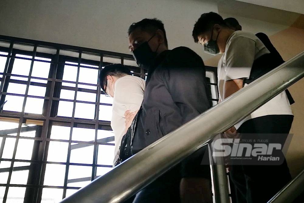 Kedua-dua suspek (baju cerah) diiringi polis di mahkamah pada Selasa.