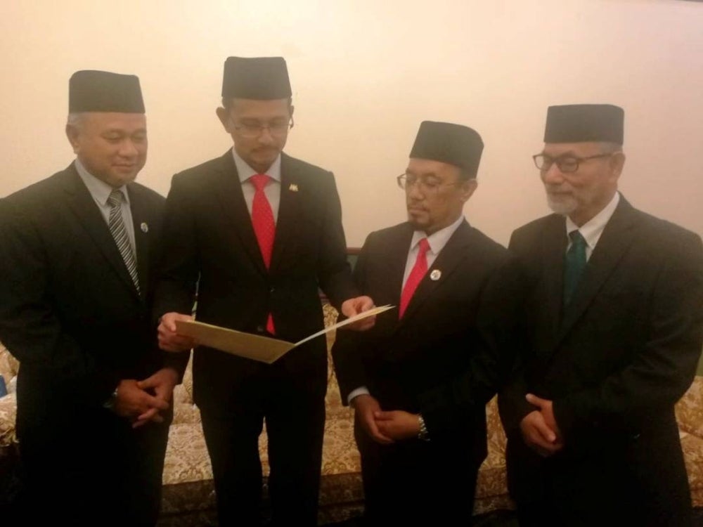 Mohd Fared (dua dari kiri) melihat surah perintah MAINJ yang melarang surau atau masjid di Johor dijadikan tempat menyebar dakyah atau perbincangan hal ehwal politik, selepas sidang akhbar di Bukit Timbalan, Johor Bahru pada Selasa.