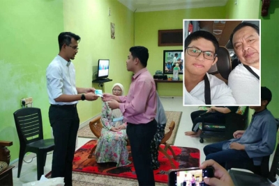 Mohd Fared ( kiri) menyampaikan bantuan MAINJ kepada Mohammad Nabil di Sri Gading Batu Pahat, pada petang Isnin.