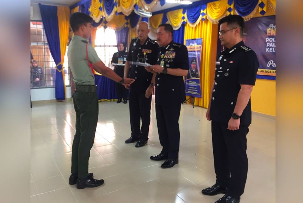 Muhamad Zaki (dua dari kanan) menyampaikan sijil kepada Sarjan Kadet Pasukan Kadet Bersatu Malaysia Darat Muhammad Hakim Sutekno (kiri).