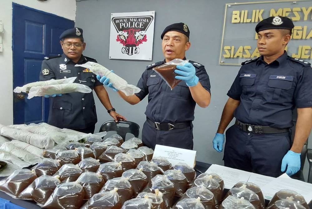 Mohd Haki (tengah) menunjukkan air dan daun ketum yang dirampas dalam Operasi Khas Perang dan Tawan di Felda Kemahang 1, Kemahang 2 dan Kemahang 3 bermula Isnin.