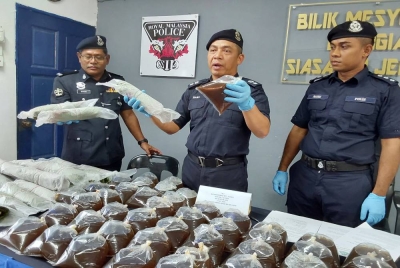 Mohd Haki (tengah) menunjukkan air dan daun ketum yang dirampas dalam Operasi Khas Perang dan Tawan di Felda Kemahang 1, Kemahang 2 dan Kemahang 3 bermula Isnin.