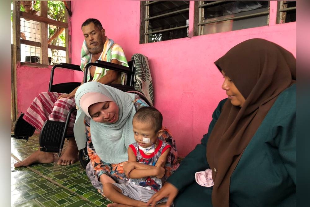 Natipah meriba Muhammad Aiman sambil diperhatikan oleh Nor Shakila (kanan) dan Juhari.